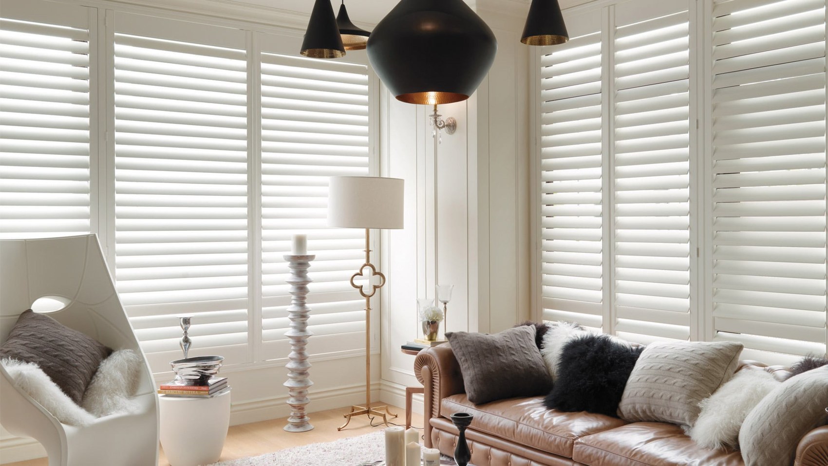 White shutters in an elegant living room with black dome pendant lights