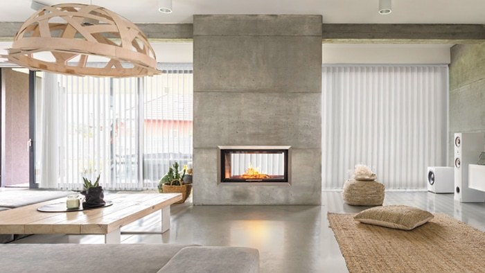 Sheer vertical panels beside a concrete fireplace
