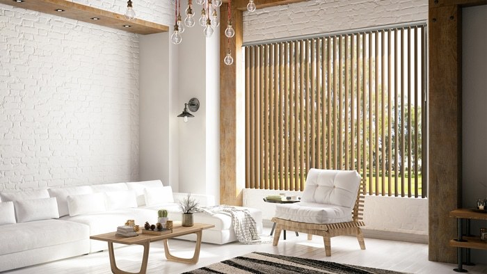 Wood-tone vertical blinds in a white brick room