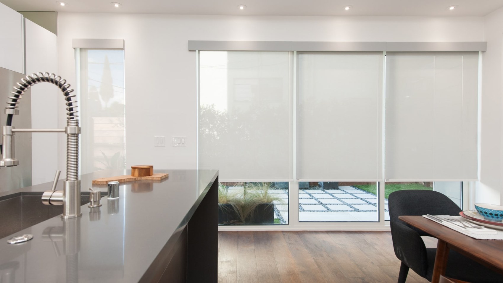 Roller shades in a modern kitchen with a large island