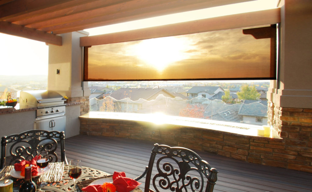 InsolRoll Oasis patio shade on an outdoor kitchen at sunset